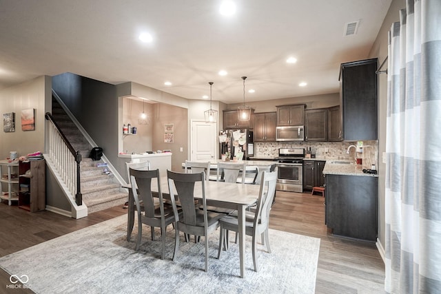 5374 John Quincy Adams Ct, Plainfield, IN 46168 - dining room featuring light wood-style flooring, stairway, recessed lighting, and baseboards