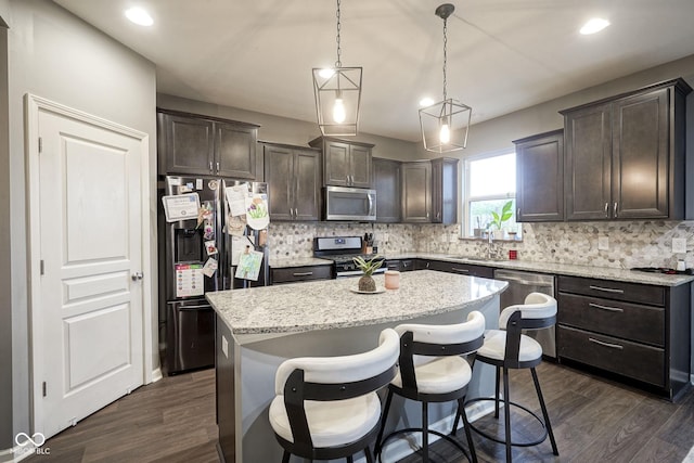 5374 John Quincy Adams Ct, Plainfield, IN 46168 - kitchen with stainless steel appliances, dark brown cabinets, a kitchen island, backsplash, and recessed lighting