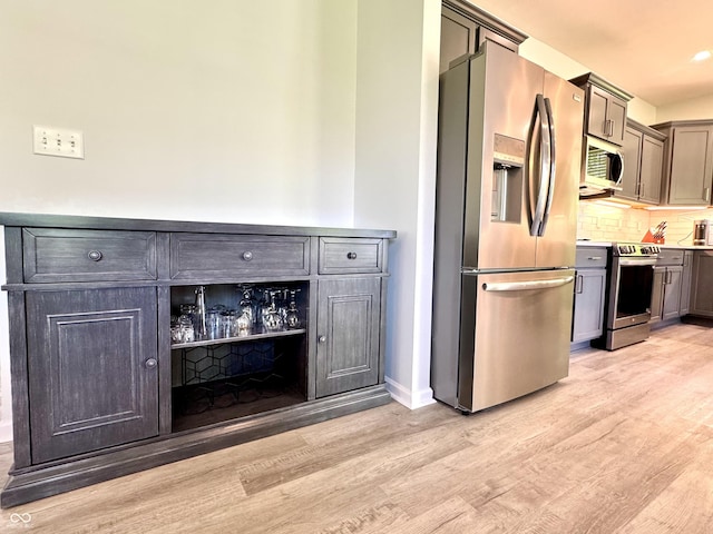 252 Patriots Lndg, Fillmore, IN 46128 - kitchen featuring appliances with stainless steel finishes, light wood-style flooring, decorative backsplash, baseboards, and light countertops