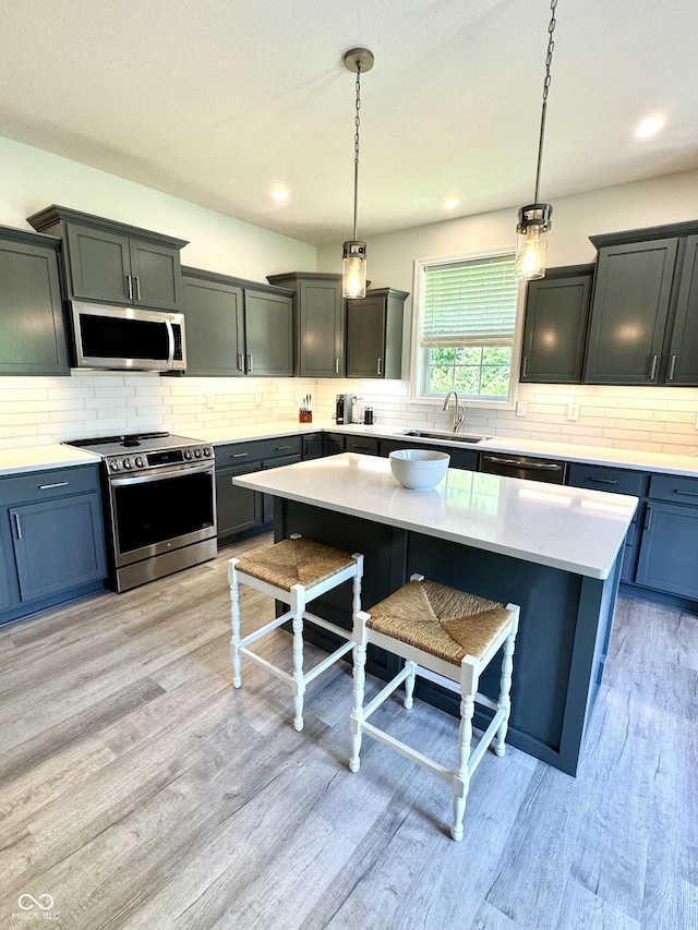 252 Patriots Lndg, Fillmore, IN 46128 - kitchen with appliances with stainless steel finishes, a sink, backsplash, a breakfast bar area, and light wood finished floors