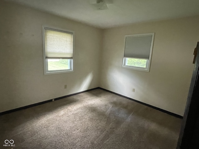 empty room featuring carpet flooring and baseboards