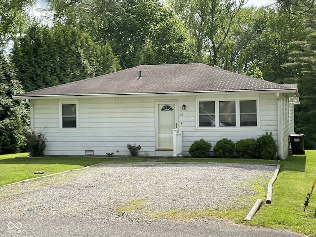 view of front of house with a front yard and roof with shingles