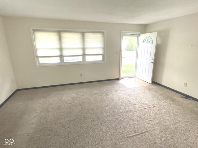 carpeted empty room with baseboards