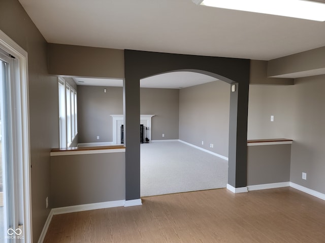 11754 Hamble Dr, Indianapolis, IN 46235 - unfurnished living room featuring arched walkways, wood finished floors, and a fireplace