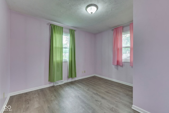 521 Elmhurst Pl, Whiteland, IN 46184 - empty room featuring a textured ceiling, wood finished floors, healthy amount of natural light, and baseboards