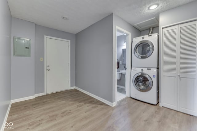 521 Elmhurst Pl, Whiteland, IN 46184 - laundry area featuring stacked washer / drying machine, electric panel, light wood finished floors, baseboards, and attic access
