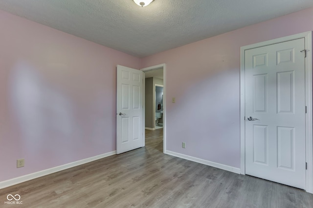 521 Elmhurst Pl, Whiteland, IN 46184 - unfurnished bedroom featuring light wood-style floors, baseboards, and a textured ceiling