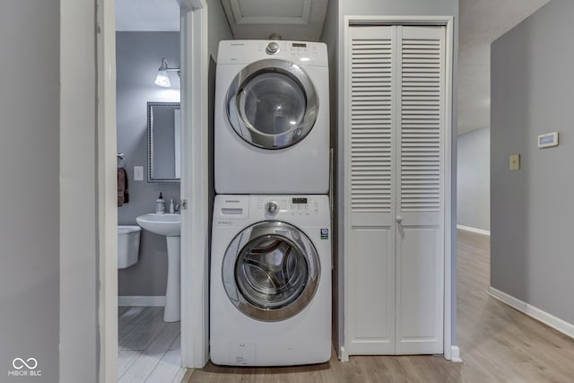 521 Elmhurst Pl, Whiteland, IN 46184 - laundry room featuring stacked washing machine and dryer, light wood-style flooring, and baseboards