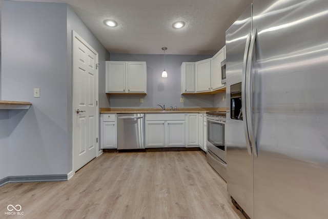 521 Elmhurst Pl, Whiteland, IN 46184 - kitchen with appliances with stainless steel finishes, light wood-style floors, white cabinets, a textured ceiling, and recessed lighting