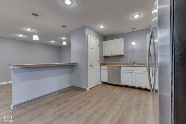 521 Elmhurst Pl, Whiteland, IN 46184 - kitchen featuring appliances with stainless steel finishes, a sink, baseboards, light wood-type flooring, and white cabinets