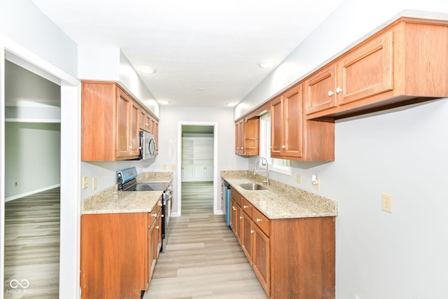 12289 Charing Cross Rd, Carmel, IN 46033 - kitchen with appliances with stainless steel finishes, a sink, light wood finished floors, light stone countertops, and brown cabinets