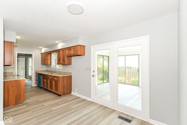 12289 Charing Cross Rd, Carmel, IN 46033 - kitchen featuring brown cabinets, a sink, light wood-style flooring, baseboards, and dishwashing machine
