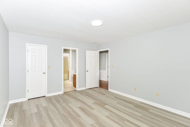 12289 Charing Cross Rd, Carmel, IN 46033 - unfurnished bedroom with light wood-style flooring, baseboards, and ensuite bath