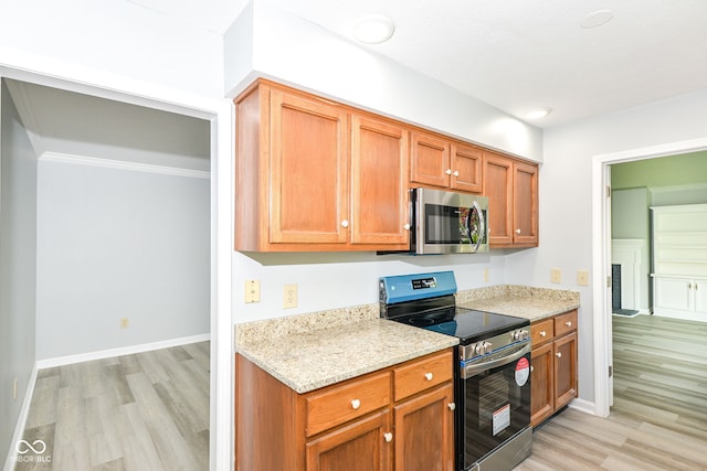 12289 Charing Cross Rd, Carmel, IN 46033 - kitchen featuring stainless steel appliances, light wood-style flooring, light stone counters, and ornamental molding