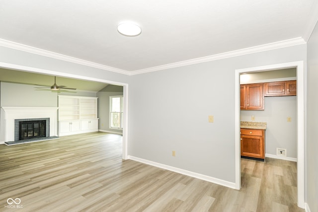 12289 Charing Cross Rd, Carmel, IN 46033 - unfurnished living room with light wood-style floors, crown molding, a ceiling fan, baseboards, and a fireplace