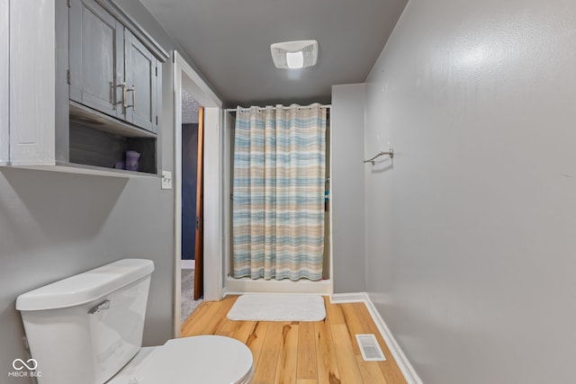 5594 S County Road 550 E, Greencastle, IN 46135 - full bathroom featuring toilet, wood finished floors, a shower with curtain, and baseboards