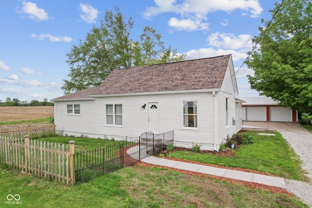 5594 S County Road 550 E, Greencastle, IN 46135 - new england style home with a detached garage, a shingled roof, and an outbuilding