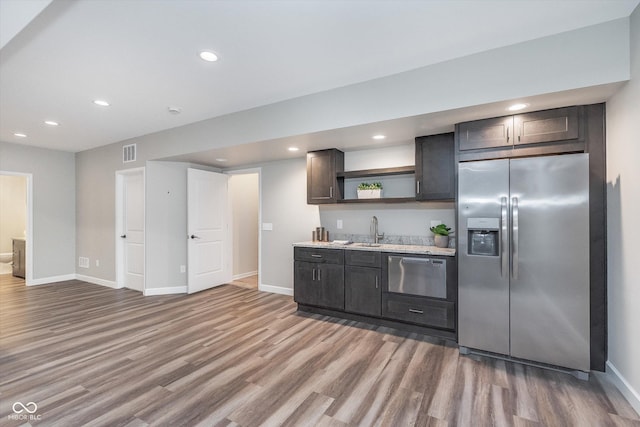 16071 Prince Ct, Noblesville, IN 46062 - kitchen with appliances with stainless steel finishes, open shelves, light wood finished floors, baseboards, and a sink