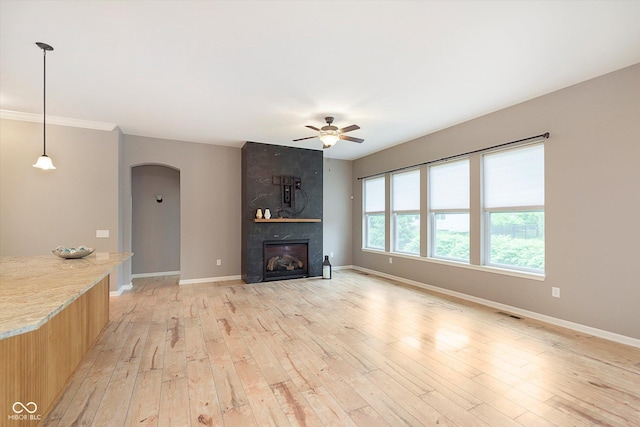 16071 Prince Ct, Noblesville, IN 46062 - unfurnished living room featuring arched walkways, a ceiling fan, baseboards, and light wood-style flooring