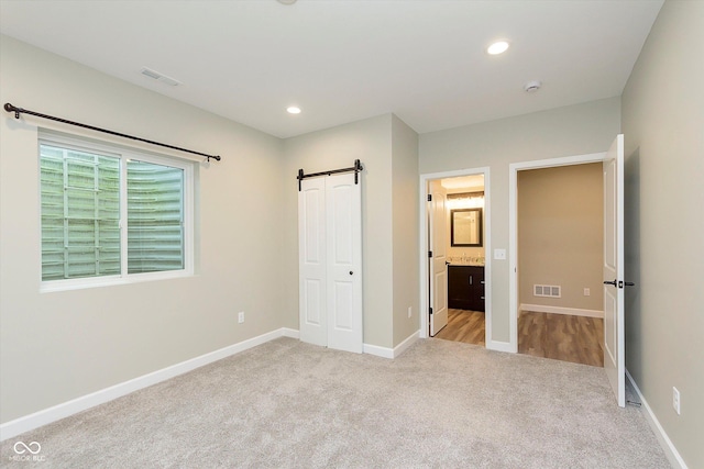 16071 Prince Ct, Noblesville, IN 46062 - unfurnished bedroom featuring carpet, baseboards, a barn door, connected bathroom, and recessed lighting