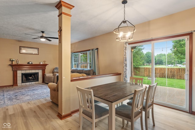 7978 Park Meadows Dr, Brownsburg, IN 46112 - dining room with light wood-type flooring, a ceiling fan, plenty of natural light, and a tiled fireplace