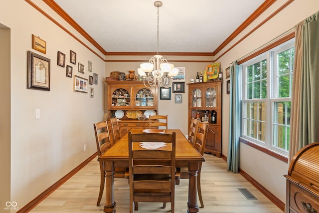 7978 Park Meadows Dr, Brownsburg, IN 46112 - dining space featuring light wood-style floors, a chandelier, baseboards, and crown molding