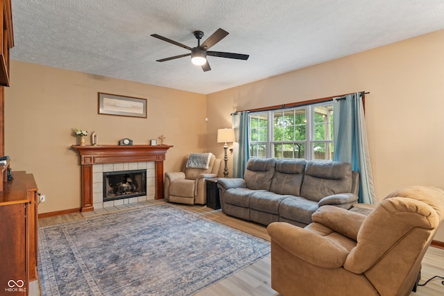 7978 Park Meadows Dr, Brownsburg, IN 46112 - living room with light wood-type flooring, ceiling fan, a textured ceiling, and a fireplace