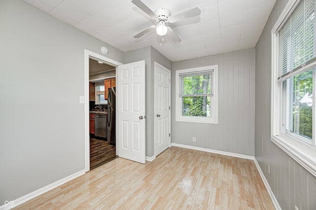 4621 E 17th St, Indianapolis, IN 46218 - unfurnished bedroom with baseboards, light wood-style flooring, a sink, a ceiling fan, and freestanding refrigerator