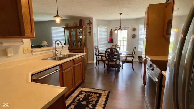 994 Youngs Creek Dr, Franklin, IN 46131 - kitchen featuring appliances with stainless steel finishes, a sink, brown cabinetry, a chandelier, and pendant lighting