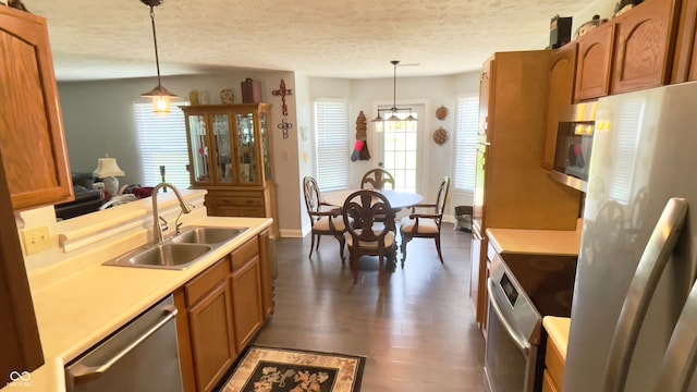 994 Youngs Creek Dr, Franklin, IN 46131 - kitchen featuring stainless steel appliances, a sink, brown cabinets, decorative light fixtures, and light countertops