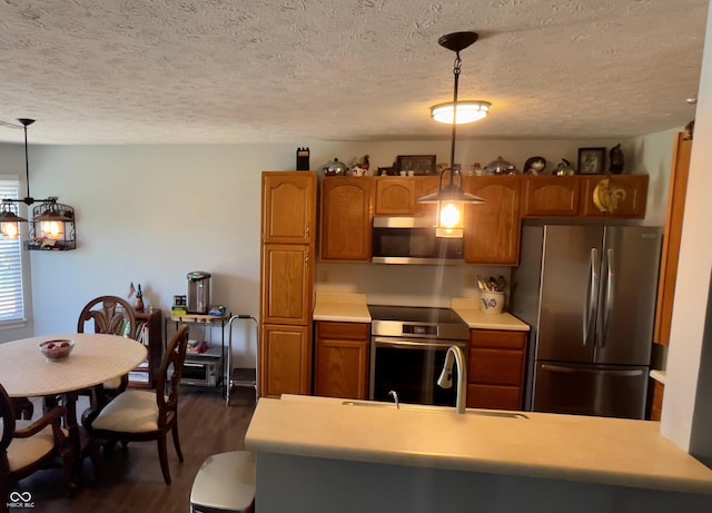 994 Youngs Creek Dr, Franklin, IN 46131 - kitchen featuring appliances with stainless steel finishes, dark wood-style floors, brown cabinetry, and a textured ceiling