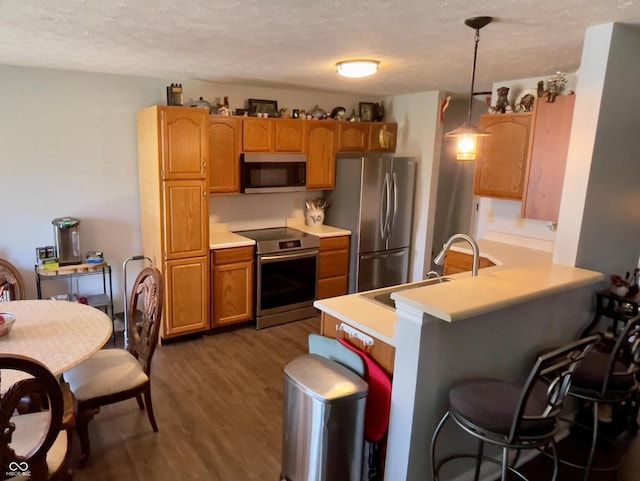 994 Youngs Creek Dr, Franklin, IN 46131 - kitchen featuring stainless steel appliances, dark wood-style flooring, a sink, a textured ceiling, and light countertops