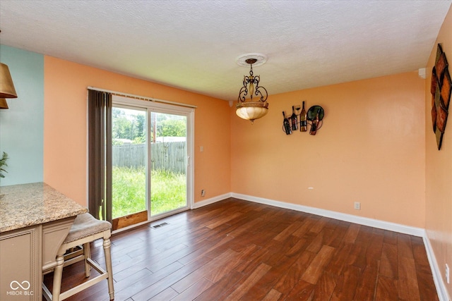 2519 N Boehning St, Indianapolis, IN 46219 - unfurnished dining area with dark wood-style flooring, baseboards, and a textured ceiling
