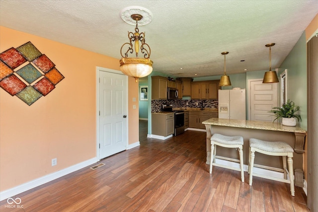 2519 N Boehning St, Indianapolis, IN 46219 - kitchen with stainless steel appliances, baseboards, a peninsula, backsplash, and dark wood finished floors