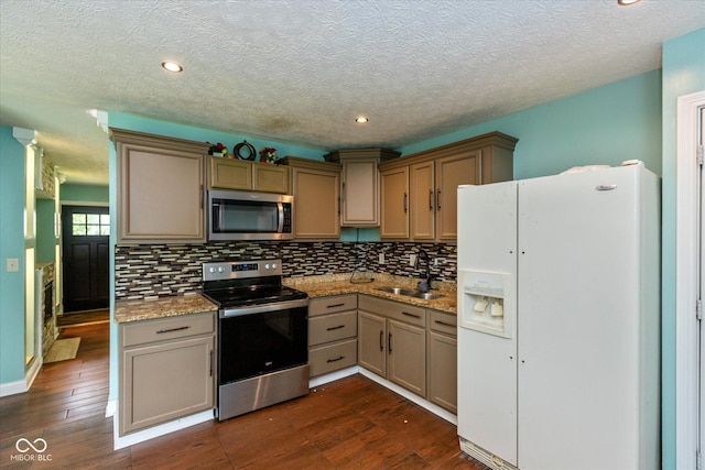 2519 N Boehning St, Indianapolis, IN 46219 - kitchen with appliances with stainless steel finishes, a sink, decorative backsplash, dark wood finished floors, and a textured ceiling