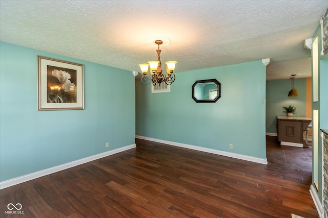 2519 N Boehning St, Indianapolis, IN 46219 - empty room with a textured ceiling, dark wood-type flooring, baseboards, and a chandelier