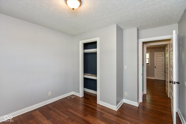 2519 N Boehning St, Indianapolis, IN 46219 - unfurnished bedroom with dark wood-style floors, baseboards, and a textured ceiling