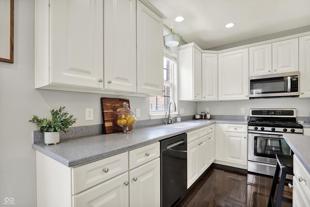 73 11th St NW, Carmel, IN 46032 - kitchen with stainless steel appliances, a sink, dark wood-style floors, white cabinetry, and recessed lighting