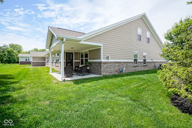695 Overcup St, Westfield, IN 46074 - back of house featuring brick siding, a patio, a lawn, and a shingled roof