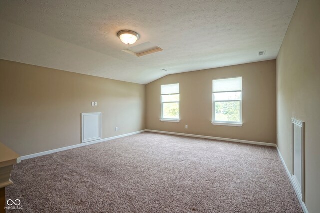695 Overcup St, Westfield, IN 46074 - carpeted spare room with attic access, vaulted ceiling, baseboards, and a textured ceiling