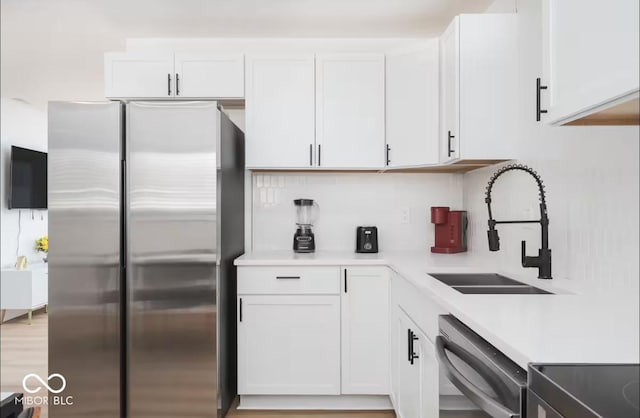 8744 Montery Ct, Indianapolis, IN 46226 - kitchen with freestanding refrigerator, dishwashing machine, a sink, light countertops, and white cabinets