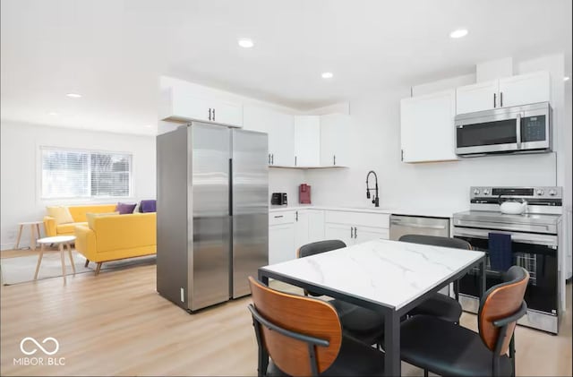 8744 Montery Ct, Indianapolis, IN 46226 - kitchen with appliances with stainless steel finishes, a sink, white cabinets, light countertops, and recessed lighting