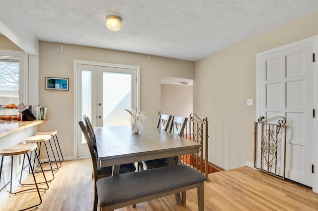 249 Spring St, Plainfield, IN 46168 - dining area with light wood finished floors, a textured ceiling, french doors, and baseboards