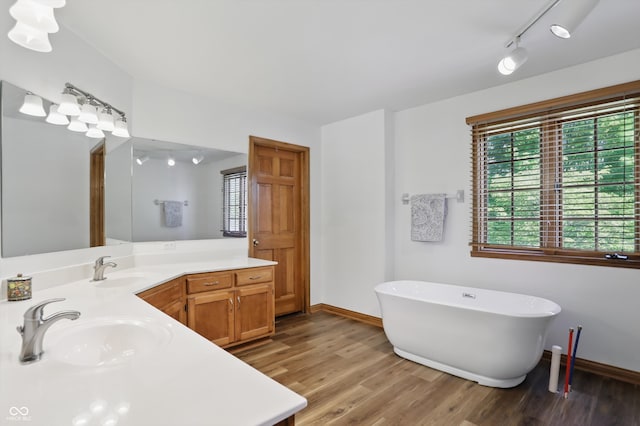 12335 Old Stone Dr, Indianapolis, IN 46236 - bathroom with a soaking tub, vanity, wood finished floors, and baseboards