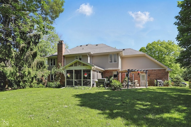 12335 Old Stone Dr, Indianapolis, IN 46236 - rear view of house featuring a chimney, brick siding, a sunroom, a lawn, and a patio