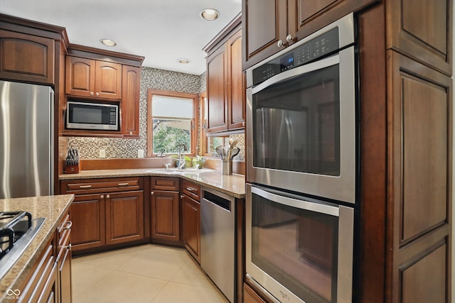 12335 Old Stone Dr, Indianapolis, IN 46236 - kitchen featuring appliances with stainless steel finishes, a sink, light stone counters, light tile patterned flooring, and recessed lighting