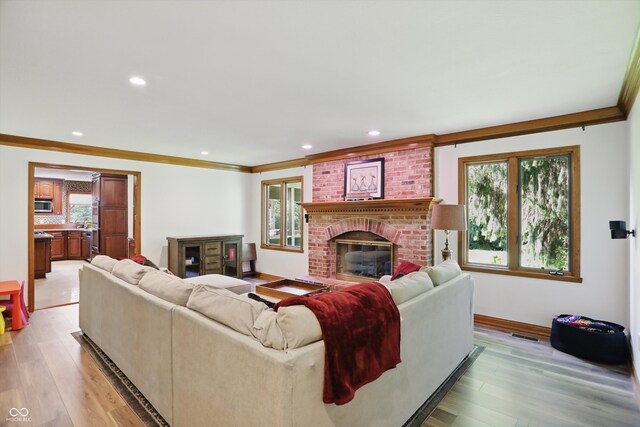 12335 Old Stone Dr, Indianapolis, IN 46236 - living area featuring healthy amount of natural light, a brick fireplace, crown molding, recessed lighting, and baseboards