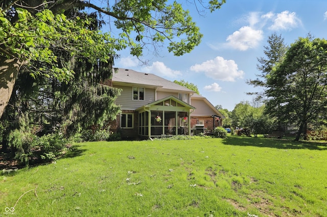 12335 Old Stone Dr, Indianapolis, IN 46236 - rear view of property with brick siding, a sunroom, and a yard