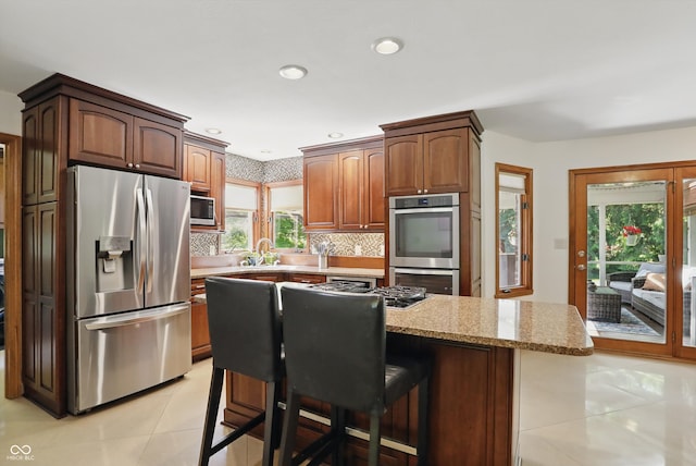 12335 Old Stone Dr, Indianapolis, IN 46236 - kitchen featuring appliances with stainless steel finishes, light tile patterned flooring, healthy amount of natural light, tasteful backsplash, and recessed lighting