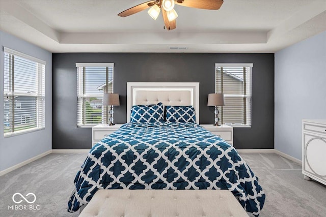 13495 Forest Glade Dr, Fishers, IN 46037 - bedroom with light colored carpet, a tray ceiling, baseboards, and multiple windows
